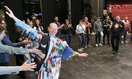Davis, smiling, arms outstretched, circles the stage in the Robe with people sticking their hands out to reach him.